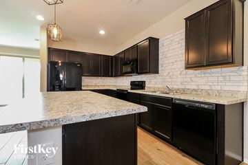 Surprise house for rent - a kitchen with black appliances and granite counter tops