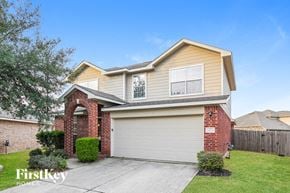 Cypress house for rent - a beige and brick house with a garage door
