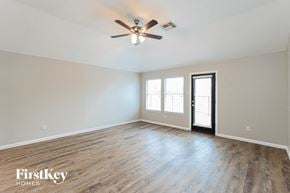 Cypress house for rent - an empty living room with wood floors and a ceiling fan