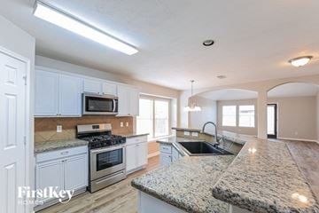 Cypress house for rent - a large kitchen with white cabinets and granite counter tops