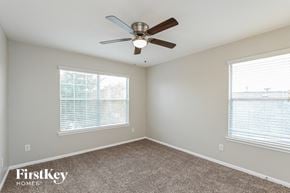Cypress house for rent - an empty bedroom with a ceiling fan and two windows