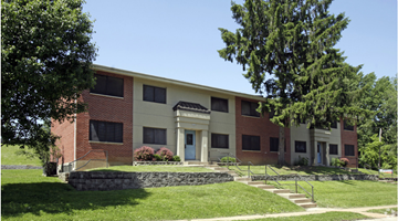 Jennings apartment for rent - the front of a building with a green lawn and trees