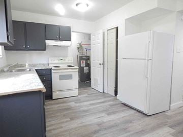 Jennings apartment for rent - a renovated kitchen with white appliances and black cabinets