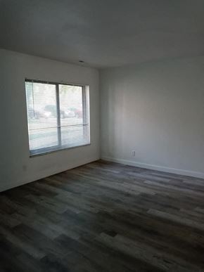 Jennings apartment for rent - an empty living room with a window and wooden floors