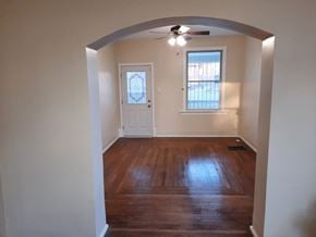 Cincinnati house for rent - an empty living room with wooden floors and a white door