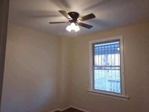 Cincinnati house for rent - a bedroom with a ceiling fan and a window