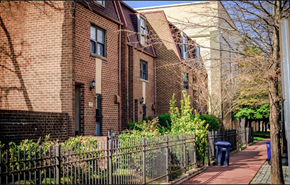 Washington apartment for rent - a sidewalk in front of a brick building with a metal fence