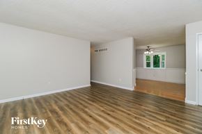 St Louis house for rent - the living room and dining room of an empty house with wood floors