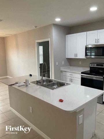 Cape Coral house for rent - a kitchen with a white counter top and a sink