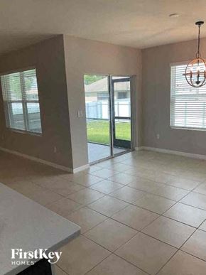 Cape Coral house for rent - an empty living room with a tile floor and a sliding glass door