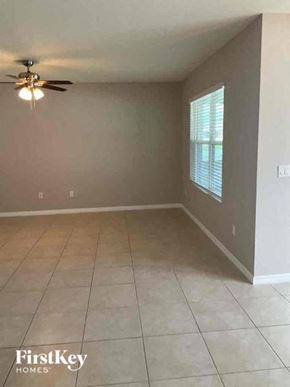 Cape Coral house for rent - a empty living room with a ceiling fan and a tiled floor