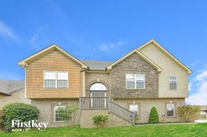 Clarksville house for rent - A two-story house with a stone facade and a large front porch.