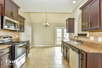 Clarksville house for rent - A kitchen with brown cabinets and a stainless steel oven.