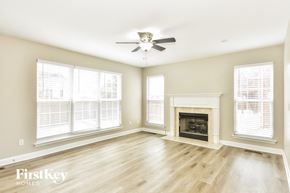 Hermitage house for rent - a living room with a fireplace and a ceiling fan