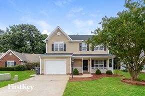 Winston Salem house for rent - a beige house with a white garage door and a lawn