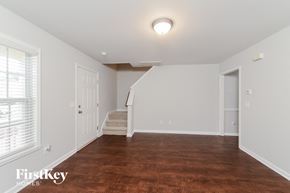 Winston Salem house for rent - a renovated living room with a hardwood floor and white walls