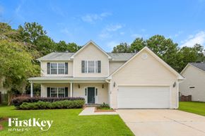 Moncks Corner house for rent - a white house with a green lawn and trees