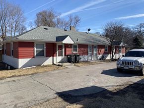 Omaha apartment for rent - a red and white house with a car parked outside