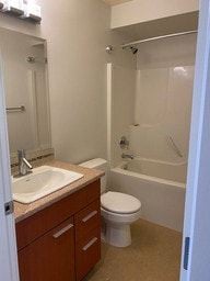 Nanaimo apartment for rent - A white toilet sits in a bathroom next to a sink.
