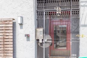Oakland apartment for rent - A red car is behind a metal gate with the number 421 on it.