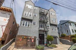 Oakland apartment for rent - A grey building with a fire escape on the front.
