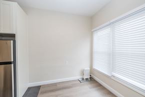 Oakland apartment for rent - A room with a refrigerator on the left and a radiator on the floor.