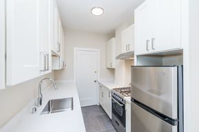 Oakland apartment for rent - A kitchen with white cabinets and a stainless steel refrigerator.