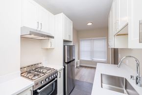 Oakland apartment for rent - A modern kitchen with white cabinets and stainless steel appliances.