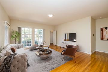Oakland apartment for rent - A living room with a white couch and a grey rug.