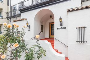 Oakland apartment for rent - A white building with a red carpeted staircase leading to a door.