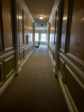 Los Angeles apartment for rent - A long hallway with green walls and wood paneling.
