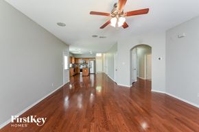 Fort Worth house for rent - A spacious room with wooden floors and a ceiling fan.