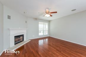 Fort Worth house for rent - A room with a fireplace and a ceiling fan.