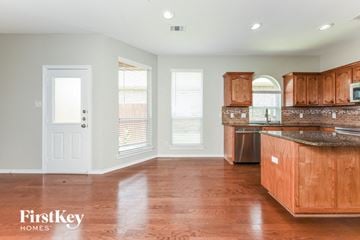 Fort Worth house for rent - A kitchen with wooden cabinets and a countertop.
