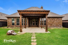 Edmond house for rent - backyard of a brick house with a wooden porch and a gazebo
