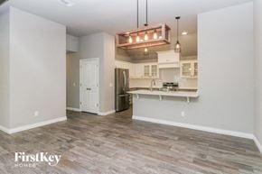 Edmond house for rent - an empty living room with a kitchen and a chandelier