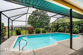 Cape Coral house for rent - A pool under a green roof with Firstkey Homes written on the side.