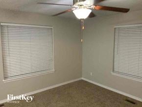 Colorado Springs house for rent - an empty room with a ceiling fan and two windows