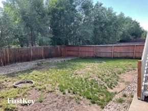 Colorado Springs house for rent - a backyard with a fence and grass and trees
