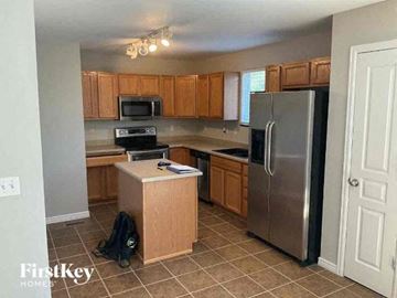 Colorado Springs house for rent - a kitchen with wooden cabinets and a stainless steel refrigerator
