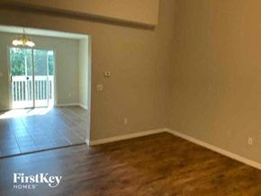 Colorado Springs house for rent - an empty living room with a wood floor and a doorway