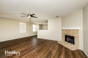 Mckinney house for rent - a living room with a fireplace and a ceiling fan