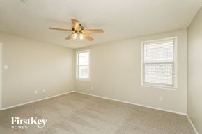 Mckinney house for rent - a bedroom with a ceiling fan and a window