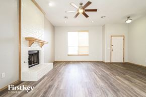 Edmond house for rent - A spacious room with a fireplace and a ceiling fan.