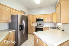 Edmond house for rent - A kitchen with wooden cabinets and a stainless steel refrigerator.
