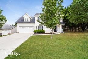 High Point house for rent - A white house with a black roof and a tree in front.