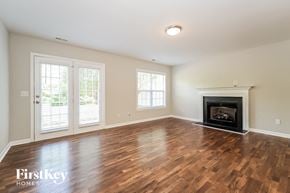 High Point house for rent - A room with a fireplace and wooden floors.