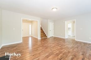 High Point house for rent - A spacious room with wooden floors and white walls.