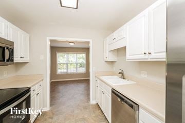 High Point house for rent - A kitchen with white cabinets and a stainless steel refrigerator.