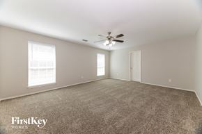 Denton house for rent - A spacious room with a carpeted floor, a ceiling fan, and a window with blinds.
